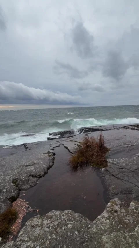 Tracking shot powerful ocean wave crashing on rocky shore in stormy weather Vídeos de archivo 333605245