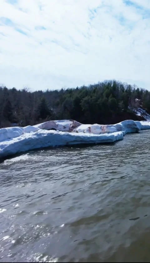 Tracking shot powerful ocean waves crashing against icy shore in winter Vídeos de archivo 333605172