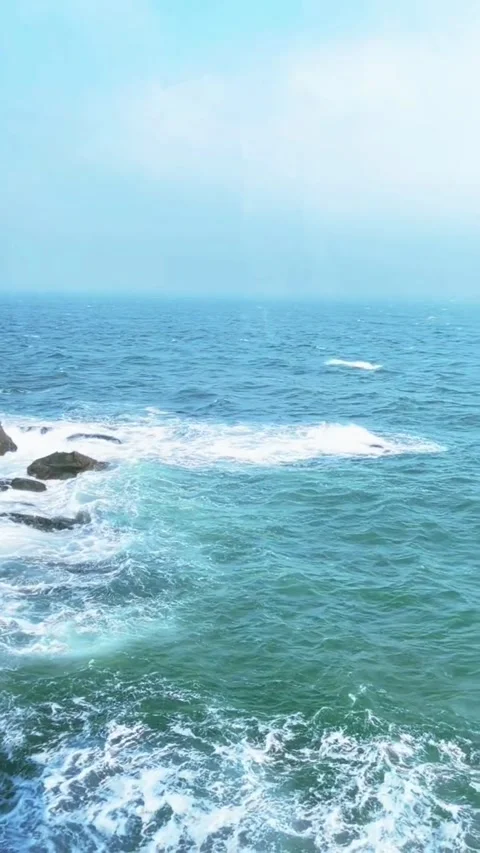 Tracking shot powerful ocean waves crashing on rocky shore in HD Vidéo 333605308