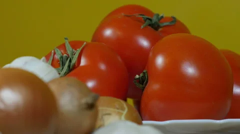 Tracking shot from red tomatoes to black and white onion, close up. Stock Footage 60568763