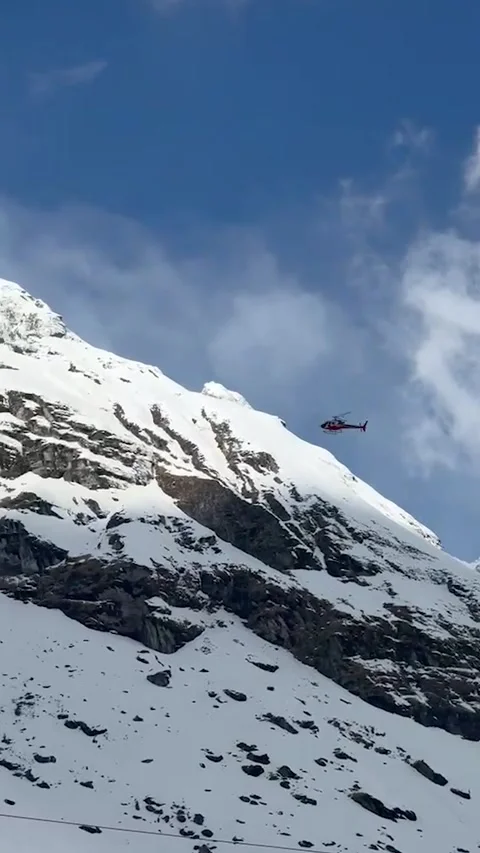 Tracking shot of a rescue helicopter flying near massive snow covered mount.. Stock-Footage 337449170
