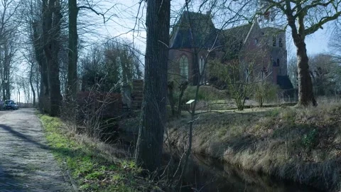 Tracking shot revealing an old brick church in a rural landscape Видео 331188780