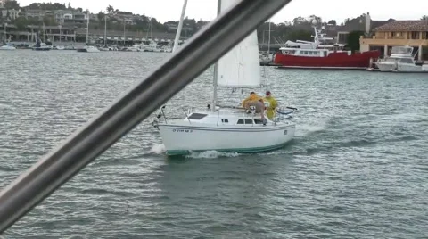 Tracking shot of sailboat attacking anchored Race Committee motorboat with wa Stock Footage 67488519