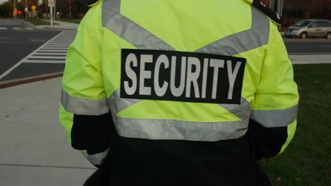 Tracking shot of security guard in uniform patrolling commercial area. Stock Footage 153888556