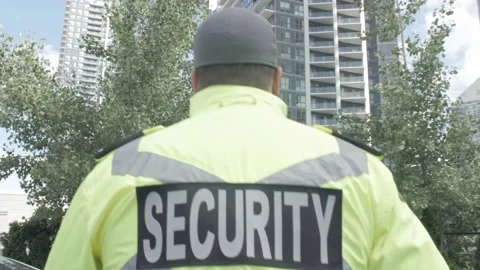 Tracking shot of security guard in uniform patrolling residential area. Stock Footage 153888583