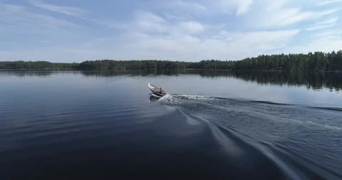 Tracking Shot of the Small Boat on a Tranquil Lake in Middle of a Forest Video stock 85890200