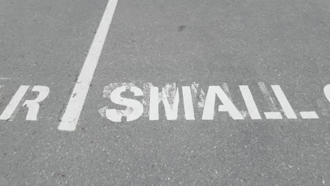 Tracking shot of Small Car parking space text on asphalt Stock-Footage 332590059