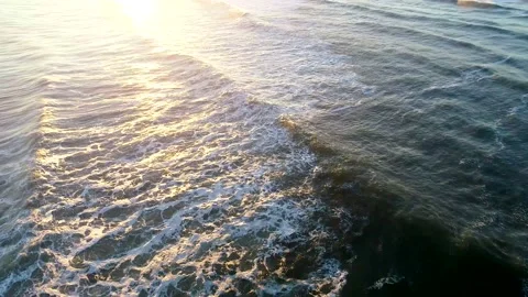Tracking shot on small waves in the ocean with sun reflection off the water Stock Footage 155466113