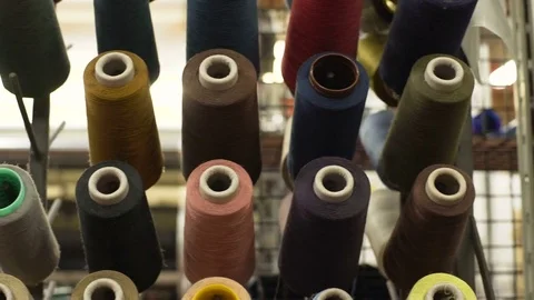 Tracking shot of spools of thread of different colors in modern textile factory. Video stock 74752053