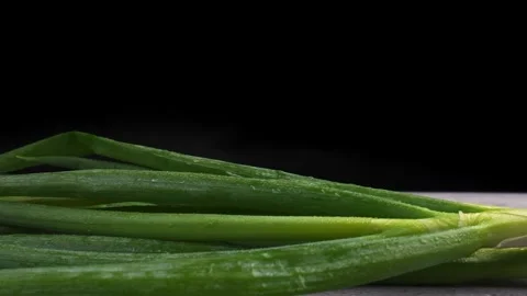 Tracking shot of spring onion on dark background Stock Footage 277682436