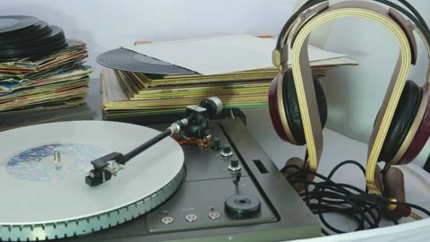 Tracking shot with stacks of 45 33 rpm vinyl records and a turntable with the Stock-Footage 139037507