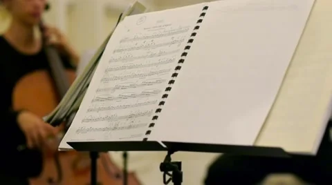 Tracking shot of string quartet from music sheet to musician Stock Footage 46065631