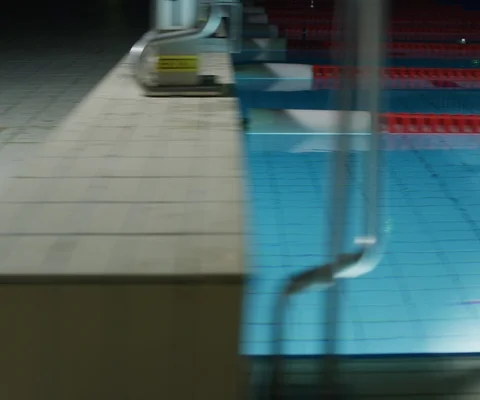 Tracking shot of swimmer diving into pool and swimming at night Stock Footage 147058050