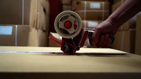 Tracking Shot Of Tape Rolling Over Box Stock Footage 155981845