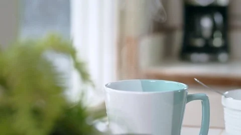 Tracking shot of tea bag bobbing in teal mug of steaming hot water Stock Footage 84477968