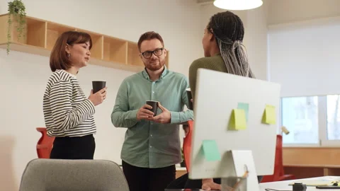 Tracking shot of three diverse young male and female office colleagues having Stock Footage 265014363