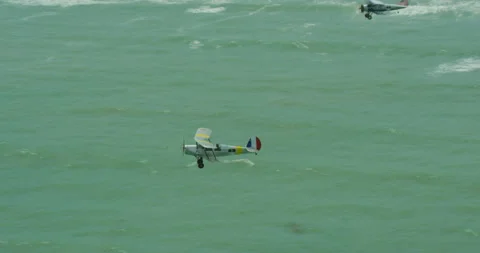 Tracking shot of three light aircrafts flying over the ocean Stock Footage 310542425