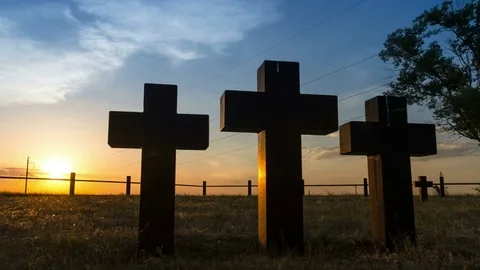 Tracking shot of Three massive stone crosses on the graves of the old cemetery Stock Footage 75329091