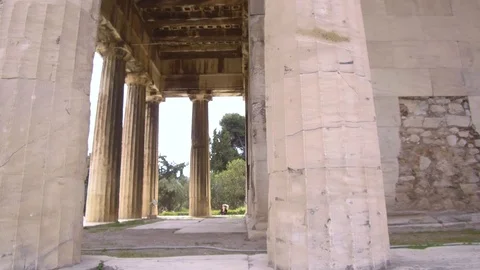 Tracking shot tilt up camera moves around Temple of Hephaestus in roman agora Stock Footage 92439347