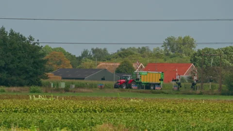 Tracking Shot of Tractor Driving with Tipper Trailer Crossing Railway in Stock Footage 345868306