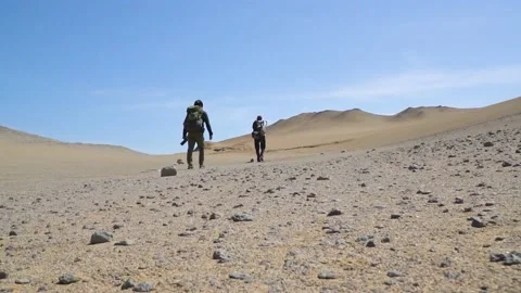 Tracking Shot Of Two Campers Hiking In Wild Paracas Desert Under Sun, Stock-Footage 226326230