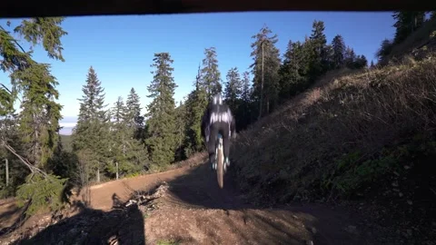 Tracking shot of two mountain bikers on MTB jumping over a mountain bike trail Stock Footage 150450459