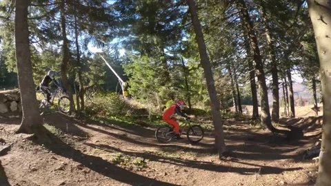 Tracking shot of two professional mountain bikers riding MTB mountain bikes Video stock 150883820