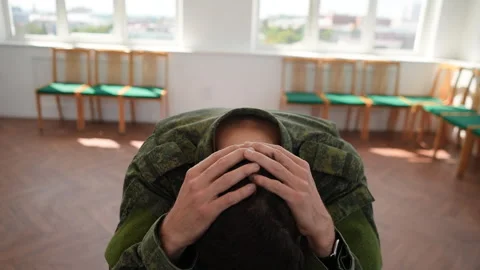 Tracking shot of upset and anxious veteran male in camouflage uniform with PTSD Stock Footage 246361307
