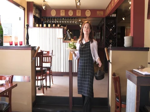 Tracking shot of a waitress serving food 動画素材 76236094