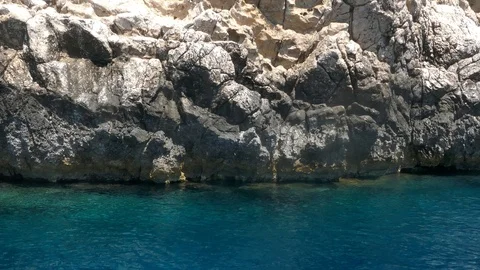 Tracking shot watching clear turquoise waters rocky cliff camera moves in sea Stock Footage 92103597