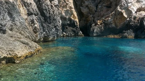 Tracking shot watching clear turquoise waters rocky cliff camera moves in sea Stock Footage 92103601