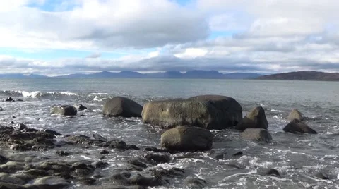 Tracking shot of waves and rocks on the shore of the Sound of Jura Stock Footage 65413249