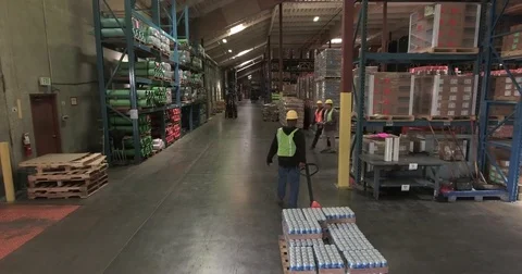 Tracking shot of a worker pulling a pallet truck Stock Footage 76225498