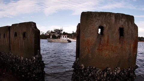 Tracking shot with yachts framed between concrete barriers. Video stock 129011372
