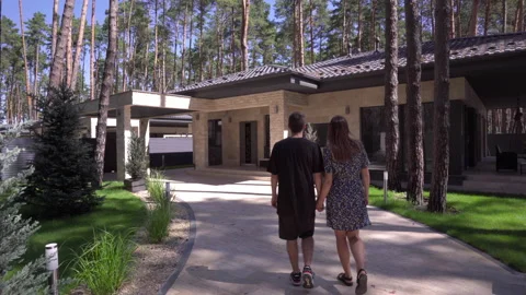 Tracking Shot of Young Couple Walking Together to the Modern House  Stock Footage 138896460