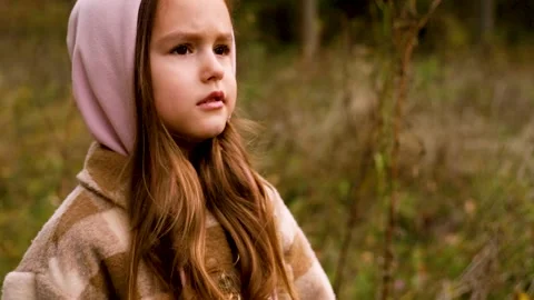 Tracking shot of young girl changing expressions in forest during autumn Stock Footage 346622436