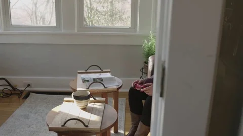 Tracking shot of a young lady gaming on a television in her sunroom Stock Footage 70809737