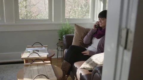 Tracking shot of young lady smiling and talking on cell phone Stock Footage 70809499