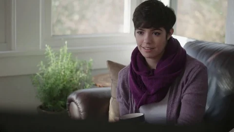 Tracking shot of young lady watching television and smiling Stock Footage 70809457