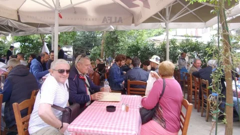 Tracking side view camera moves forward in street people sitting in restaurant 스톡 동영상 92440520