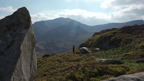 Tracking slider shot of a man and his tent wild camping in the British mountains Vidéo 203778565