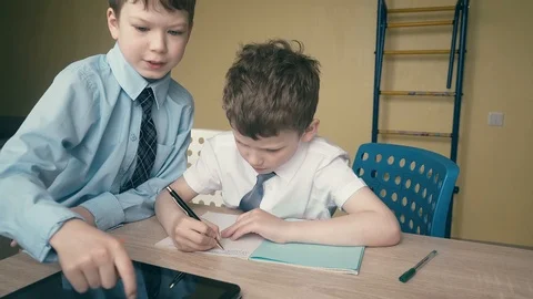 Tracking, Slow motion: Pupils do homework, write numbers in notebooks, help each Stock Footage 105098308