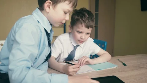 Tracking, Slow motion: Pupils do homework, write numbers in notebooks, help each Stock Footage 105098356