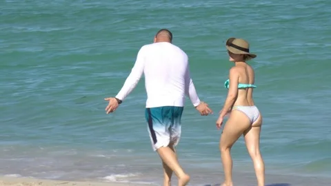Tracking Slow Motion Shot of Couple Walking By the Beach Stock Footage 75324968