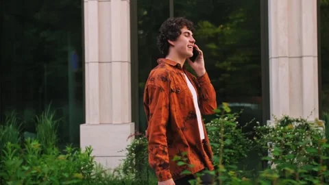 Tracking slow motion shot of happy successful young casual man talking Stock Footage 243843250