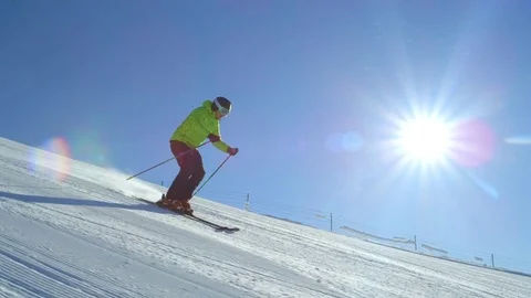 TRACKING SLOW MOTION: Skier doing fast turns on a freshly morning groomed piste Stock Footage 80869250