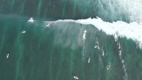 Tracking surfers catch big wave into whitewash in Uluwatu Bali 4K Drone Footage Stock Footage 103222361