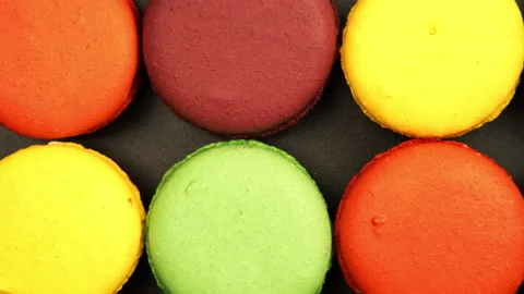 TRACKING: Top view of a Rows of Colorful Macaroons on a black table Vídeos de archivo 142619053