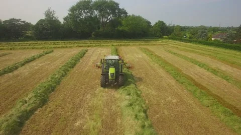 Tracking a tractor in British countryside as it passes underneath Stock Footage 64763986