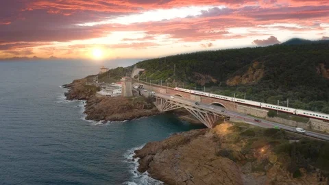 Tracking of Train on the Cliff near the Ocean at Sunset Stock Footage 120651379